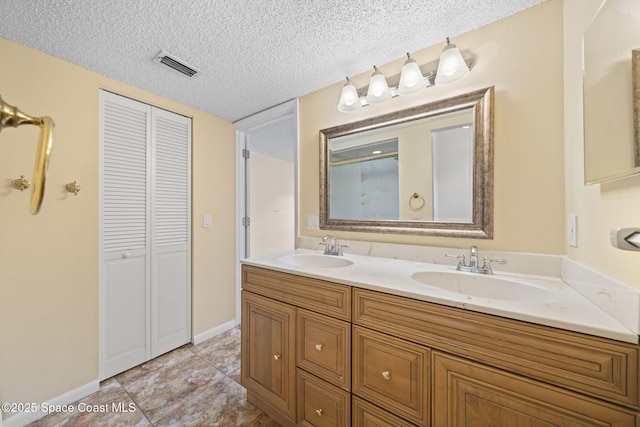 1401 Ruffin Cir SE, Palm Bay, FL 32909 - bathroom featuring a closet, double vanity, a textured ceiling, tile patterned floors, and baseboards