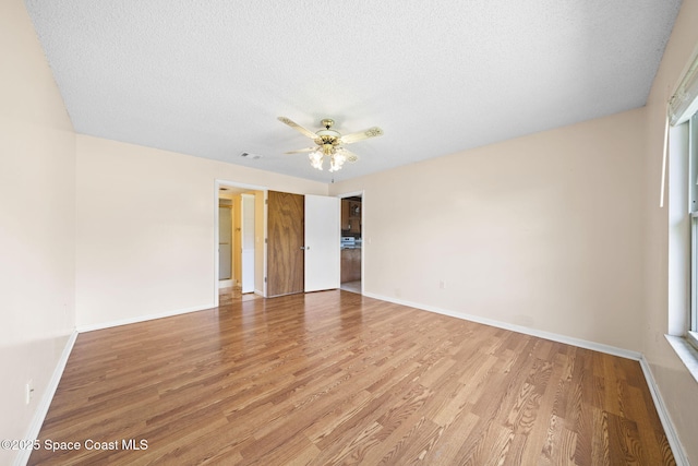 1401 Ruffin Cir SE, Palm Bay, FL 32909 - unfurnished room with light wood-type flooring, a ceiling fan, baseboards, and a textured ceiling