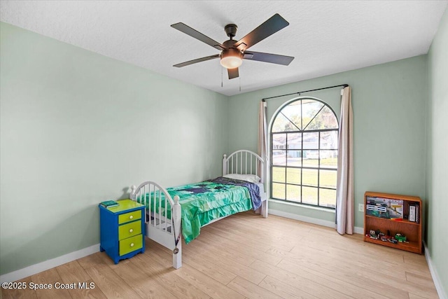 1709 Palm Ridge Rd, Melbourne, FL 32935 - bedroom featuring baseboards, wood finished floors, ceiling fan, and a textured ceiling