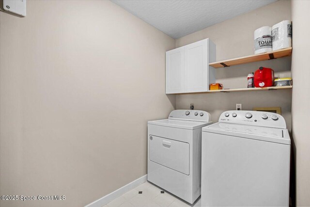 1709 Palm Ridge Rd, Melbourne, FL 32935 - washroom featuring washing machine and dryer, cabinet space, baseboards, and a textured ceiling