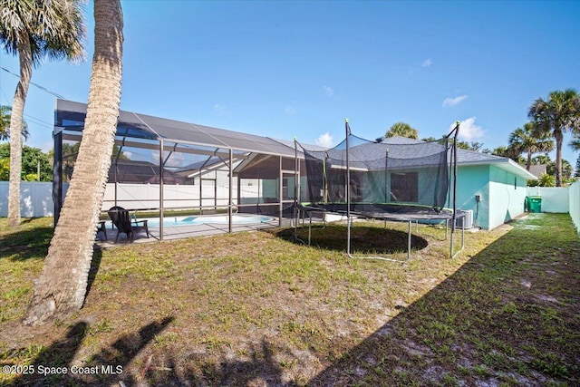 1709 Palm Ridge Rd, Melbourne, FL 32935 - back of house featuring central AC unit and a trampoline