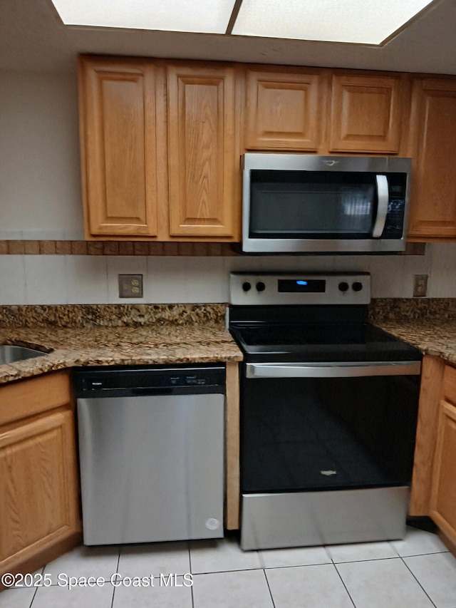 1600 Sunny Brook Ln NE Unit F106, Palm Bay, FL 32905 - kitchen featuring stainless steel appliances, light tile patterned floors, and dark stone countertops
