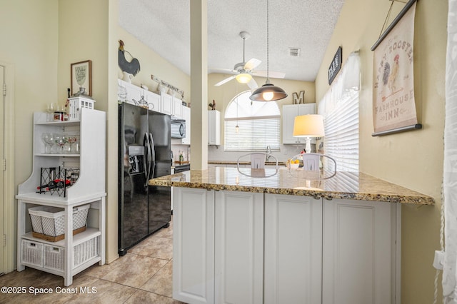 1924 Elderberry Ct NE, Palm Bay, FL 32905 - kitchen with black refrigerator with ice dispenser, a peninsula, a textured ceiling, a ceiling fan, and light stone countertops