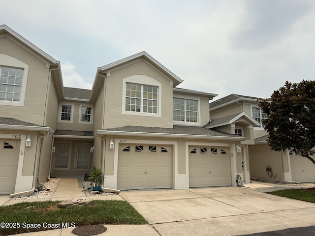 601 Trotter Ln Unit 102, Melbourne, FL 32940 - view of front of property featuring driveway, an attached garage, and stucco siding