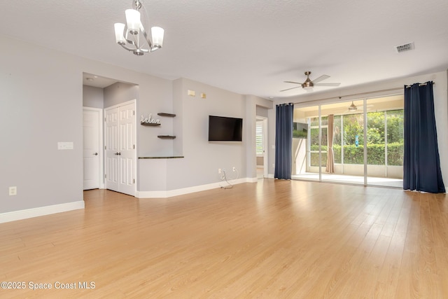 601 Trotter Ln Unit 102, Melbourne, FL 32940 - unfurnished living room featuring light wood-style floors, baseboards, a ceiling fan, and a chandelier