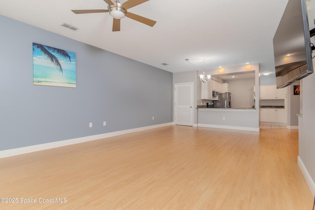 601 Trotter Ln Unit 102, Melbourne, FL 32940 - unfurnished living room featuring ceiling fan, light wood-type flooring, a chandelier, and baseboards