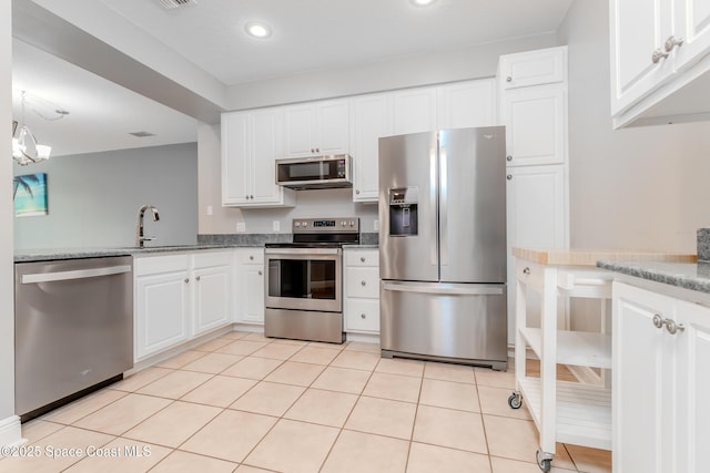 601 Trotter Ln Unit 102, Melbourne, FL 32940 - kitchen with appliances with stainless steel finishes, a sink, white cabinetry, recessed lighting, and light tile patterned floors