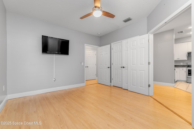 601 Trotter Ln Unit 102, Melbourne, FL 32940 - unfurnished bedroom featuring light wood-style floors, baseboards, ensuite bath, a closet, and ceiling fan