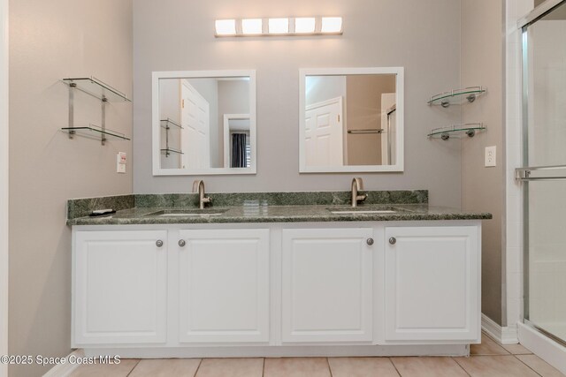 601 Trotter Ln Unit 102, Melbourne, FL 32940 - full bathroom featuring double vanity, a stall shower, and tile patterned flooring