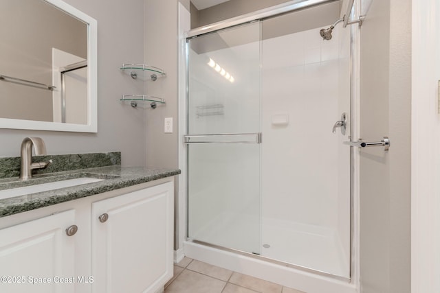 601 Trotter Ln Unit 102, Melbourne, FL 32940 - full bathroom featuring a stall shower, vanity, and tile patterned flooring