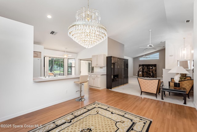 1444 Patriot Dr, Melbourne, FL 32940 - living area featuring ceiling fan, light wood-style floors, a chandelier, baseboards, and high vaulted ceiling