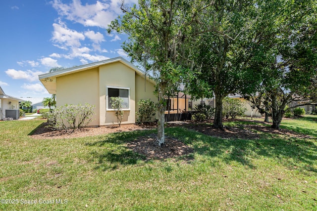 1444 Patriot Dr, Melbourne, FL 32940 - view of home's exterior with stucco siding, central AC unit, and a yard
