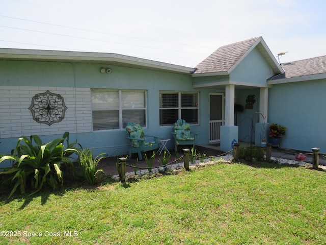 4535 Moon Rd, Titusville, FL 32780 - rear view of house featuring a lawn, stucco siding, and roof with shingles