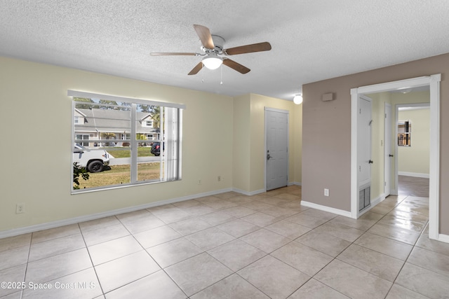 7034 Bayfront Rd, Cocoa, FL 32927 - unfurnished room featuring ceiling fan, a textured ceiling, light tile patterned flooring, and baseboards