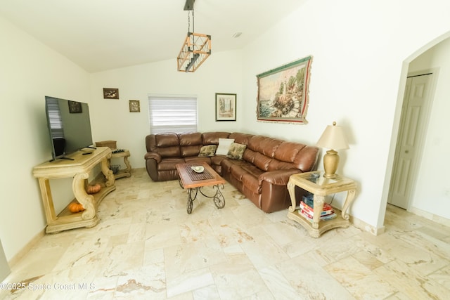 living room with arched walkways and lofted ceiling