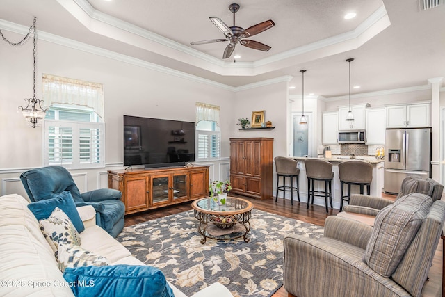 508 Lorelei Ave, Melbourne, FL 32901 - living room featuring healthy amount of natural light, a tray ceiling, dark wood-type flooring, ceiling fan, and ornamental molding