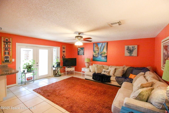 311 Clayton Ave, Melbourne, FL 32901 - living area featuring light tile patterned flooring, ceiling fan, french doors, a textured ceiling, and baseboards