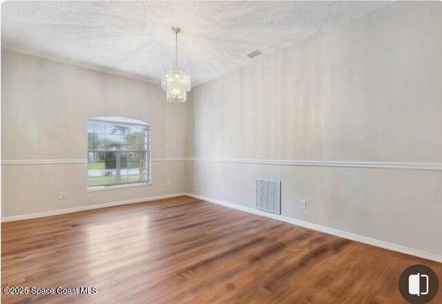 1932 Laramie Cir, Melbourne, FL 32940 - empty room with a chandelier, wood finished floors, and baseboards