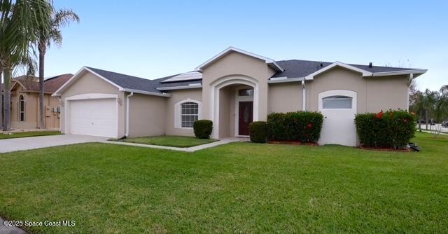 1932 Laramie Cir, Melbourne, FL 32940 - ranch-style house with roof mounted solar panels, a front lawn, an attached garage, concrete driveway, and stucco siding