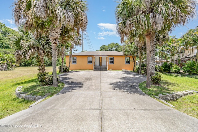 1230 Fern St Unit 1230 & 1232, Cocoa, FL 32922 - ranch-style home with concrete driveway, a front yard, and stucco siding