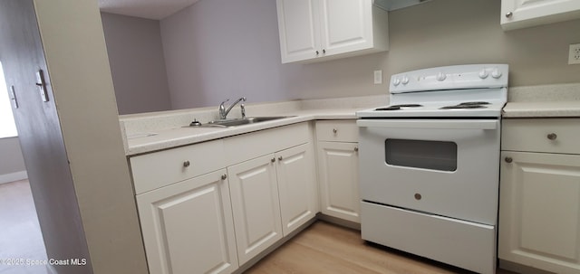 3143 Sir Hamilton Cir Unit 12, Titusville, FL 32780 - kitchen with white range with electric cooktop, a sink, light countertops, light wood finished floors, and white cabinets