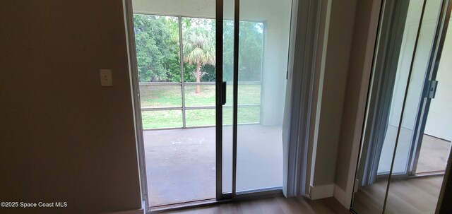 3143 Sir Hamilton Cir Unit 12, Titusville, FL 32780 - doorway to outside featuring plenty of natural light, dark wood-style floors, and baseboards