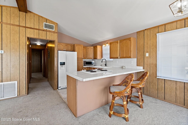 4545 Tina St, Cocoa, FL 32927 - kitchen with white appliances, wooden walls, lofted ceiling, light colored carpet, and a sink