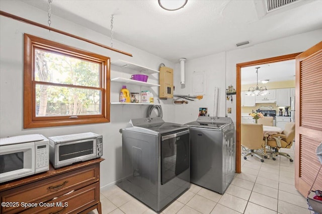1225 Colby Ln, Merritt Island, FL 32952 - washroom featuring washer and clothes dryer, light tile patterned floors, and a chandelier
