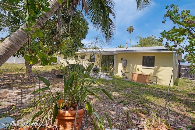 1225 Colby Ln, Merritt Island, FL 32952 - rear view of house featuring concrete block siding and metal roof