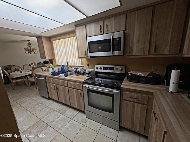3454 Pheasant Ct, Melbourne, FL 32935 - kitchen with appliances with stainless steel finishes, a sink, light tile patterned floors, a chandelier, and butcher block counters