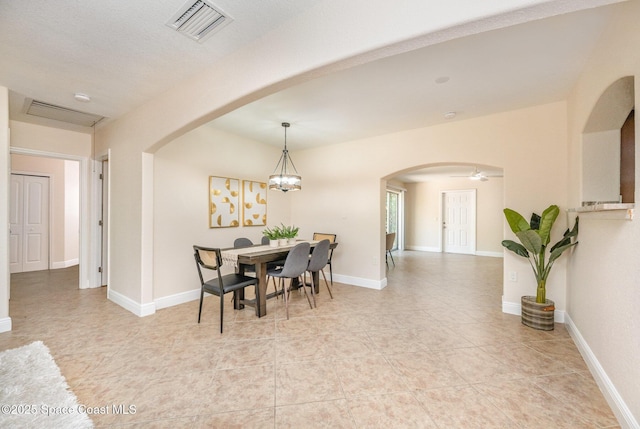dining room with arched walkways, ceiling fan, light tile patterned flooring, and baseboards