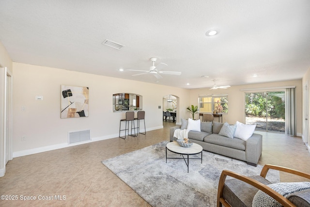 living area with arched walkways, recessed lighting, baseboards, ceiling fan, and light tile patterned floors