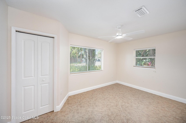 unfurnished bedroom with a closet, baseboards, and a ceiling fan