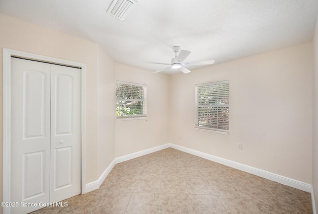 unfurnished bedroom with a closet, baseboards, and a ceiling fan