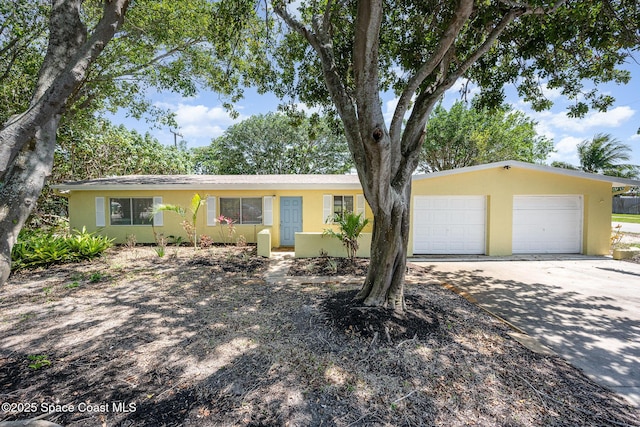 ranch-style home with stucco siding, a garage, and concrete driveway