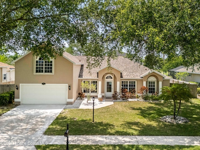 5863 Newbury Cir, Melbourne, FL 32940 - view of front of house featuring stucco siding, an attached garage, a front yard, and concrete driveway