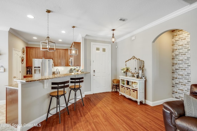 1409 Corbett Ln, Melbourne, FL 32904 - kitchen with appliances with stainless steel finishes, baseboards, a kitchen breakfast bar, light wood-type flooring, and ornamental molding
