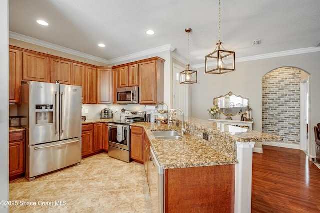 1409 Corbett Ln, Melbourne, FL 32904 - kitchen featuring appliances with stainless steel finishes, a sink, a peninsula, crown molding, and arched walkways