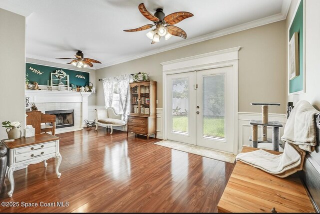 1409 Corbett Ln, Melbourne, FL 32904 - living room with a ceiling fan, french doors, a tile fireplace, wood finished floors, and crown molding