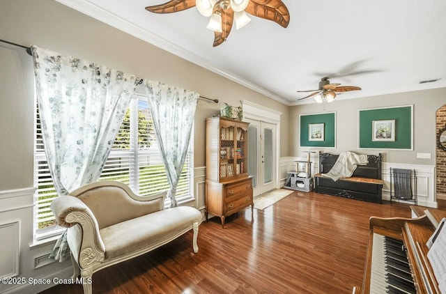 1409 Corbett Ln, Melbourne, FL 32904 - sitting room featuring a ceiling fan, wood finished floors, ornamental molding, a wainscoted wall, and a decorative wall