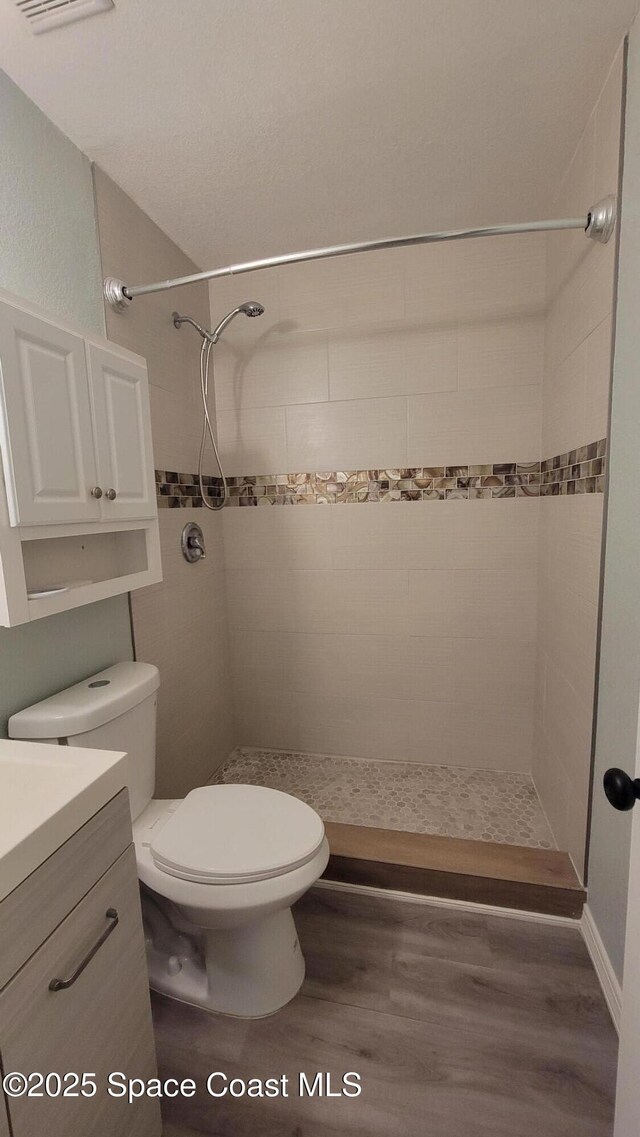 333 Galena St SW, Palm Bay, FL 32908 - full bathroom featuring vanity, wood finished floors, a stall shower, and toilet