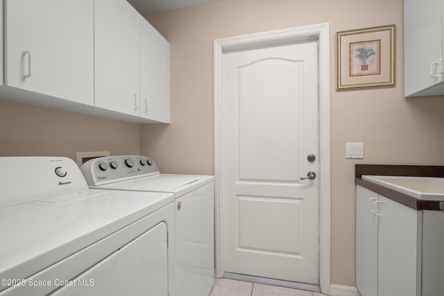448 Birchington Ln, Melbourne, FL 32940 - washroom with washing machine and dryer, cabinet space, and light tile patterned flooring