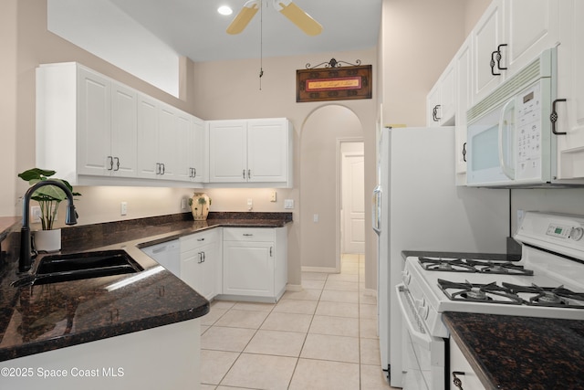 448 Birchington Ln, Melbourne, FL 32940 - kitchen with white appliances, a sink, white cabinets, arched walkways, and light tile patterned floors