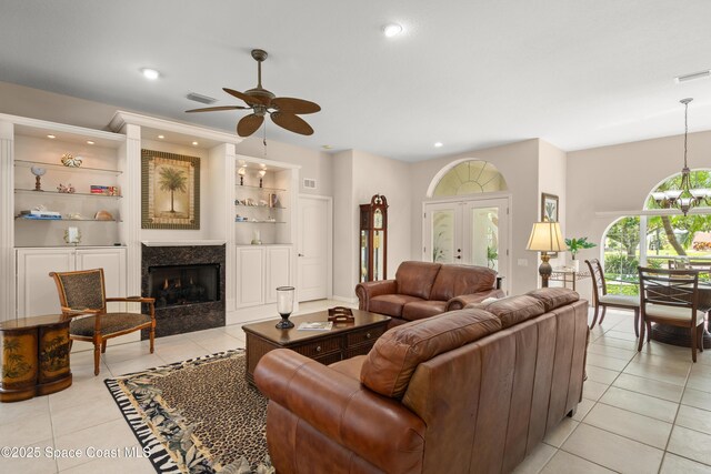 448 Birchington Ln, Melbourne, FL 32940 - living room featuring light tile patterned floors, built in shelves, a ceiling fan, a fireplace, and recessed lighting