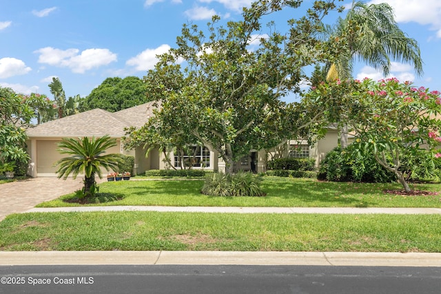 448 Birchington Ln, Melbourne, FL 32940 - obstructed view of property featuring decorative driveway, an attached garage, stucco siding, and a front yard