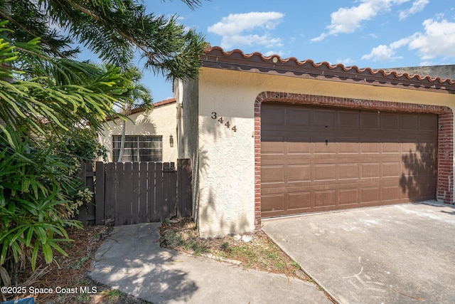 3444 Partridge Ct, Melbourne, FL 32935 - view of front of home featuring stucco siding, a garage, a tiled roof, and concrete driveway