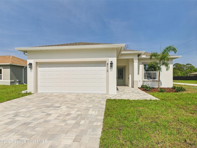 8116 97th Ct, Vero Beach, FL 32967 - prairie-style home featuring decorative driveway, stucco siding, a front yard, and an attached garage