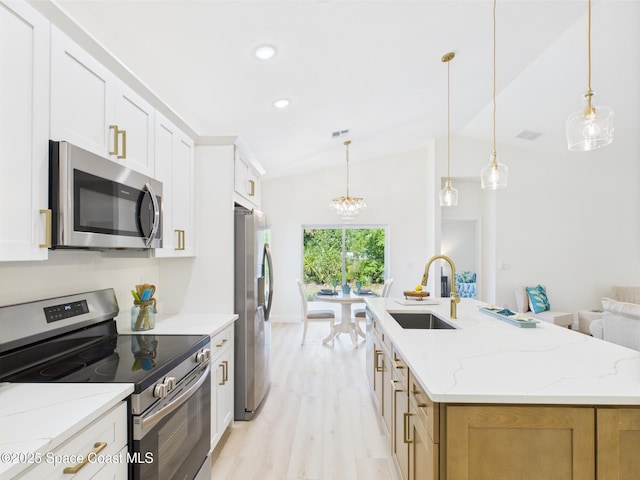 8116 97th Ct, Vero Beach, FL 32967 - kitchen with stainless steel appliances, a sink, a chandelier, light wood-style flooring, and a center island with sink
