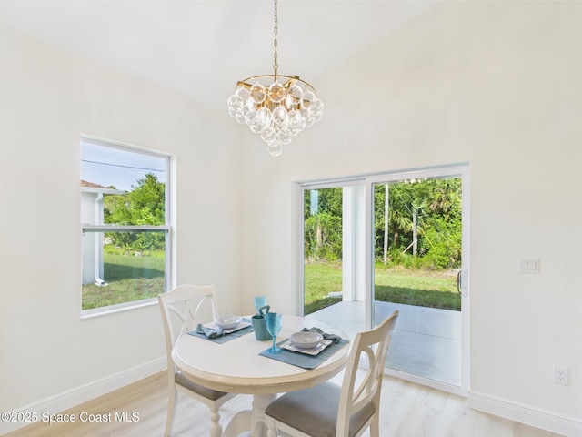 8116 97th Ct, Vero Beach, FL 32967 - dining area featuring a chandelier, light wood finished floors, baseboards, and a high ceiling