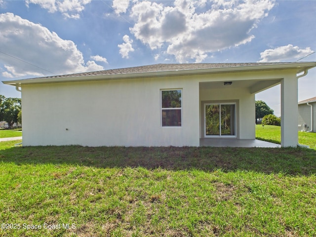 8116 97th Ct, Vero Beach, FL 32967 - back of house featuring stucco siding, a yard, and a patio